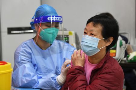 (miniature) Une employée médicale injecte un rappel du vaccin contre la COVID-19 à une résidente sur un site de vaccination temporaire à Beijing