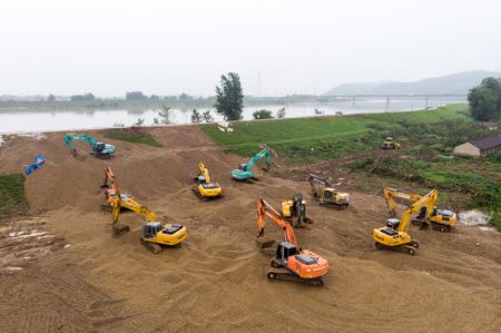 (miniature) Des pelleteuses utilisées pour arrêter l'infiltration d'une digue dans le district de Lixian