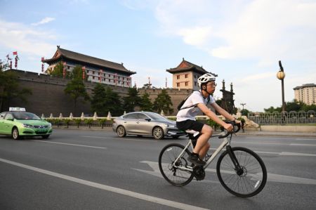 (miniature) Un habitant en vélo près des remparts anciens de Xi'an