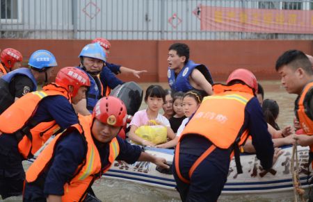 (miniature) Des gens affectés par les inondations transportés par un canot de secours dans le bourg de Guzhen