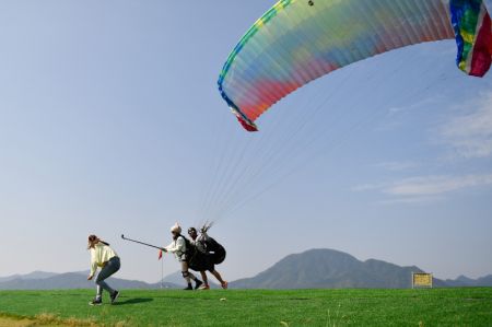 (miniature) Des touristes font du parapente à Tonglu