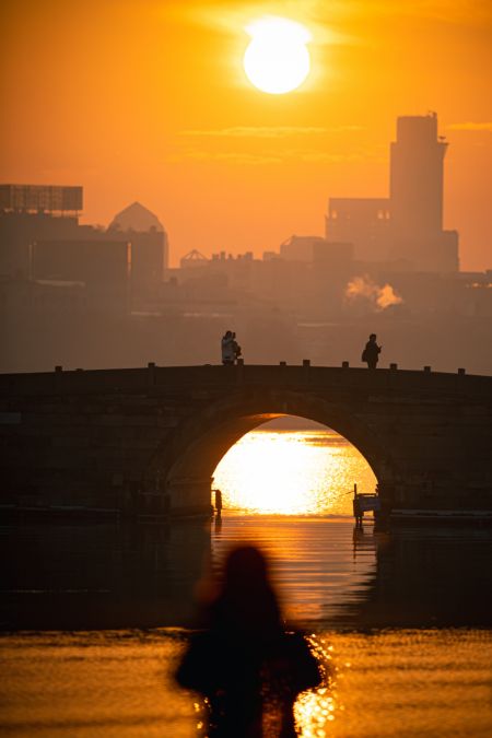 (miniature) Une touriste regarde le lever du soleil sur le pont Duanqiao