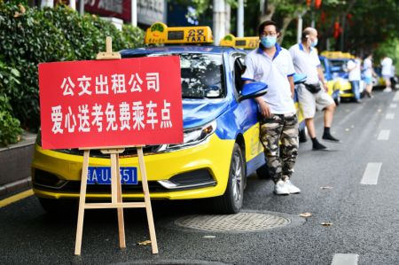 (miniature) Des chauffeurs de taxi attendent pour offrir des services gratuits aux candidats à l'extérieur du site d'examen à Guiyang