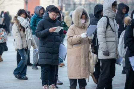 (miniature) Les candidats font la queue pour entrer dans un centre d'examen d'admission au troisième cycle à l'Université des sciences et technologies de Harbin
