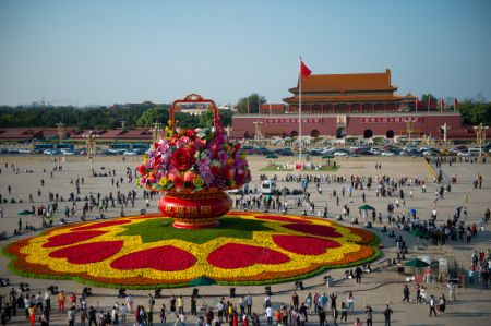 (miniature) Des touristes se prom&egrave;nent autour d'un panier de fleurs sur la place Tian'anmen &agrave; Beijing