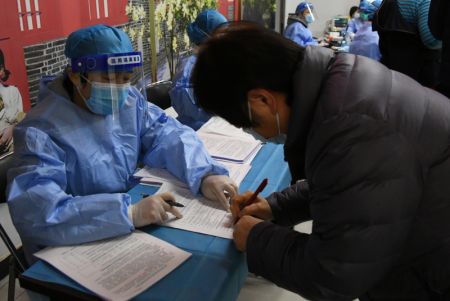 (miniature) Une employée médicale guide une résidente dans le processus d'enregistrement des informations avant de recevoir le vaccin sur un site de vaccination temporaire à Beijing