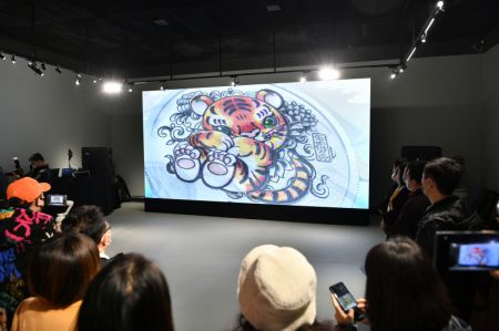 (miniature) Des participants regardent une vidéo de promotion des pièces commémoratives pour célébrer l'année du tigre du zodiaque chinois