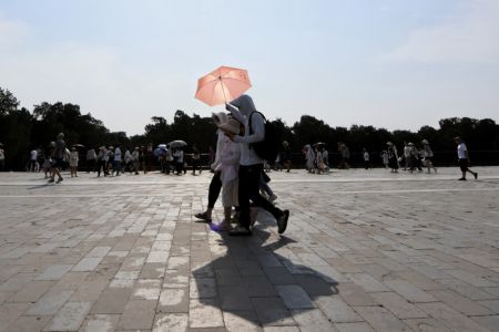 (miniature) Des touristes tiennent des parasols pour se protéger du soleil au parc du Temple du ciel