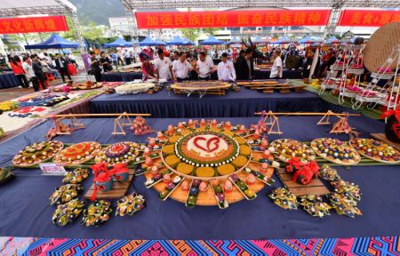 (miniature) Des juges évaluent les créations de candidats pour un concours de plats colorés à base de riz gluant sur une place culturelle du district autonome Yao de Dahua