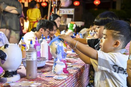 (miniature) Des enfants peignent des statues en plâtre au marché nocturne de la ville de Nanning