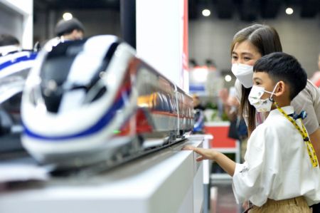 (miniature) Des visiteurs regardent un modèle de train de la China Railway Rolling Stock Corporation (CRRC) lors du salon Asia Pacific Rail 2023 à Bangkok
