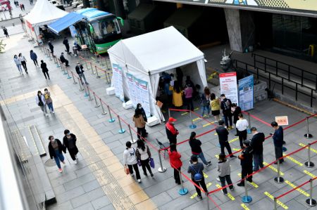 (miniature) Des habitants font la queue pour se faire vacciner devant un véhicule mobile de vaccination contre le COVID-19 près du quartier des affaires de Xidan