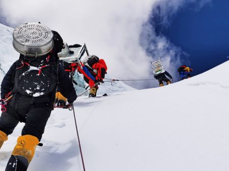 (miniature) Une photo prise le 8 mai 2020 montre que des guides de haute montagne transportent des fournitures à l'instar de l'oxygène et du carburant vers un camp à une altitude de 7