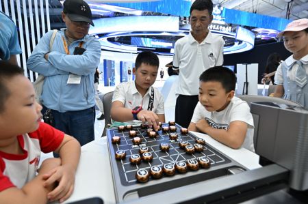 (miniature) Un garçon affronte un robot aux échecs chinois durant la Foire internationale du commerce des services de Chine (CIFTIS) 2023 au parc Shougang
