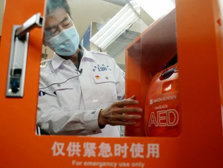 (miniature) Un employ&eacute; du centre m&eacute;dical d'urgence de Beijing pr&eacute;sente un d&eacute;fibrillateur automatique externe (DAE) &agrave; Beijing