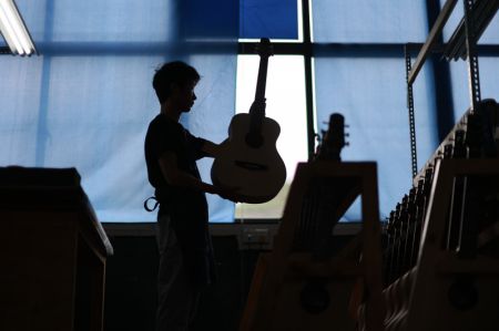 (miniature) Un travailleur fabrique une guitare dans le Parc industriel de guitares de Zheng'an