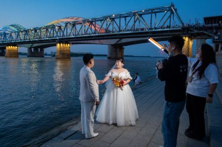 (miniature) Un couple pose pour des photos de mariage le long de la rivière Songhua