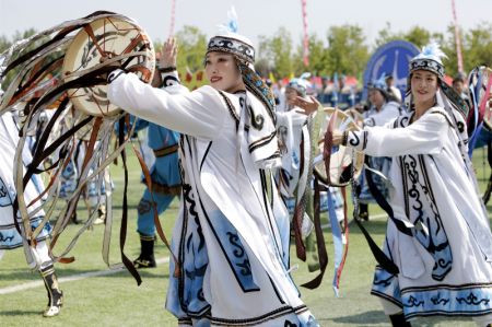 (miniature) Les Hezhe en costumes traditionnels présentent un spectacle lors de la 11e édition du Festival Wurigong de l'ethnie Hezhe