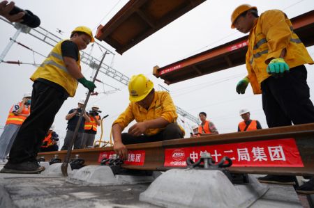 (miniature) Des ouvriers posent des rails sur le chantier de construction du chemin de fer interurbain Beijing-Xiongan dans la Nouvelle Zone de Xiongan