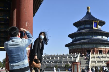 (miniature) Une touriste pose pour une photo avec le Temple du Ciel pendant les congés de la Fête nationale et de la Fête de la mi-automne