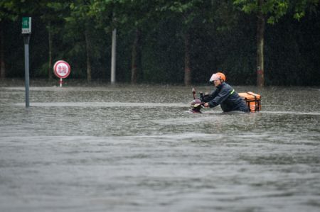 (miniature) Un livreur traverse une rue inondée de Zhengzhou