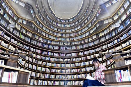 (miniature) Une visiteuse lit dans une salle de lecture dans le complexe touristique de Shan Hai Tian