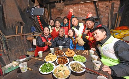 (miniature) Des bénévoles d'un centre de service prennent une photo avec une personne âgée avant leur dîner de retrouvailles dans le district de Huanglong à Xianju