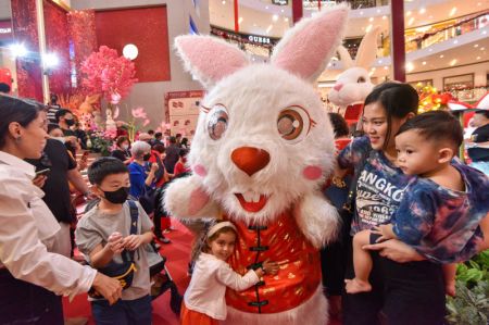 (miniature) Des personnes prises en photo avec un membre du personnel déguisé en lapin pour accueillir le Nouvel An lunaire chinois dans un centre commercial de Kuala Lumpur
