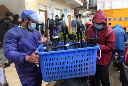 (miniature) Des habitants transfèrent des équipements d'éclairage vers une zone de secours à moto dans le village de Molang du district de Tengxian