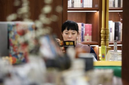 (miniature) Une lectrice lit un livre dans une librairie &agrave; Dalian