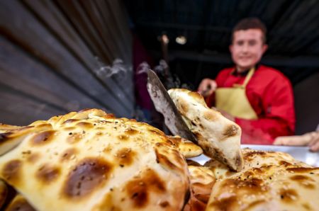 (miniature) Un vendeur prépare des aliments traditionnels dans un bazar hebdomadaire du bourg de Tokkuzak