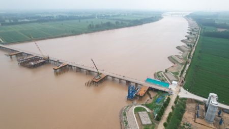 (miniature) Photo aérienne prise le 31 juillet 2023 du chantier du pont principal d'un grand pont enjambant le fleuve jaune sur le tracé de la ligne du chemin de fer à grande vitesse Xiong'an-Shangqiu