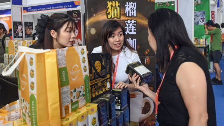 (miniature) Une visiteuse choisit des produits lors de la 21e Exposition Chine-ASEAN