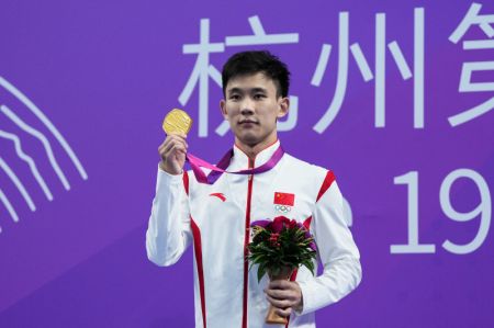 (miniature) Le médaillé d'or chinois Yang Hao prend part à la cérémonie de remise des médailles du plongeon de haut-vol (10 m) hommes aux 19es Jeux asiatiques à Hangzhou