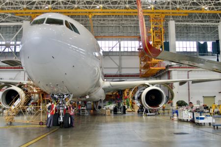 (miniature) Des techniciens de HNA Technic en plein exercice d'entretient d'un avion entrant à la base de maintenance aéronautique du Port de libre-échange de Hainan à Haikou