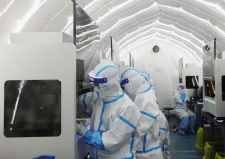 (miniature) Des membres du personnel médical travaillent dans un laboratoire de dépistage des acides nucléiques du nom de Huoyan