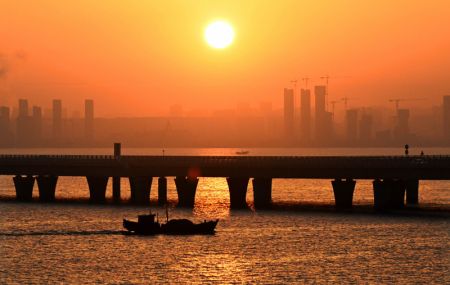 (miniature) Un bateau de pêche près du pont de la baie de Jiaozhou au lever du soleil