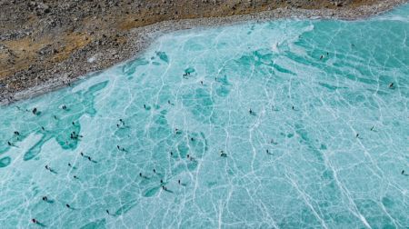 (miniature) Photo aérienne de touristes sur un lac glacé devant le mont Qungmknag