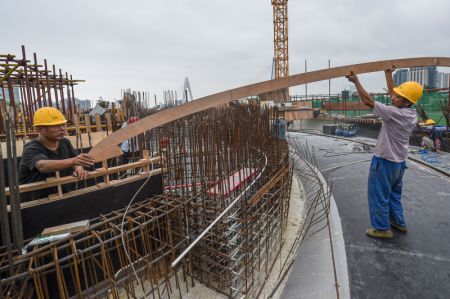 (miniature) Des ouvriers travaillent dans le site de construction de la Biblioth&egrave;que Wormwhole dans la baie de Haikou