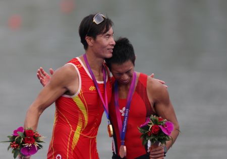 (miniature) Le médaillé d'or chinois Zhang Liang (à gauche) étreint le médaillé de bronze Chiu Hin Chun