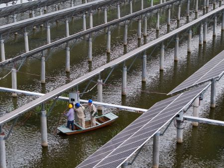 (miniature) Photo prise par un drone de techniciens de la production d'électricité patrouillant dans un projet d'énergie photovoltaïque à Yangzhou