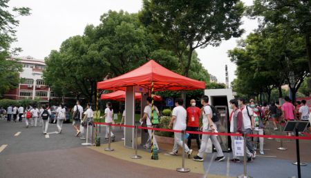 (miniature) Des élèves font la queue pour un contrôle de température corporelle avant de passer l'examen d'entrée au lycée