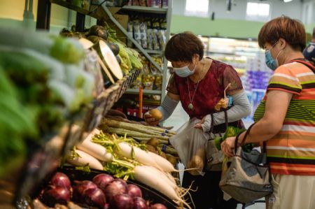 (miniature) Des consommateurs ach&egrave;tent des l&eacute;gumes dans une &eacute;picerie install&eacute;e r&eacute;cemment pr&egrave;s du march&eacute; de gros de Xinfadi &agrave; Beijing
