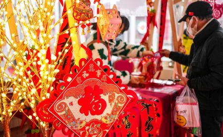 (miniature) Un habitant choisit des décorations à l'approche de la fête du Printemps à la place Lanhua dans l'arrondissement de Nanming