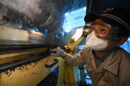 (miniature) Un technicien procède à l'entretien d'un train à grande vitesse dans un centre de maintenance d'Urumqi