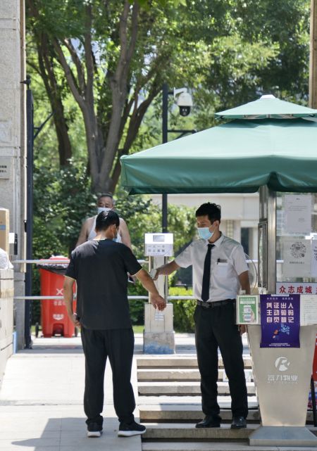 (miniature) Un habitant passe un contrôle de température avant d'entrer dans une communauté résidentielle à Jiugong