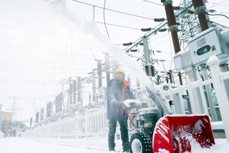 (miniature) Un employé d'une compagnie d'électricité déblaie la neige