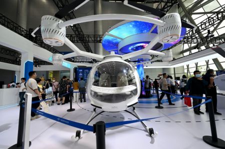 (miniature) Des visiteurs découvrent un aéronef électrique multirotor à décollage et atterrissage verticaux lors de la Convention mondiale de la fabrication 2024