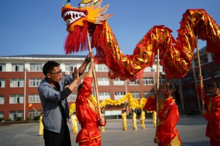 (miniature) L'entraîneur Yan Wenlong enseigne à ses élèves la danse traditionnelle du dragon à l'école primaire N° 2 de Jing'an