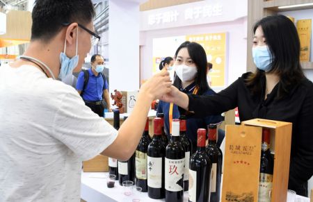 (miniature) Un visiteur déguste du vin lors du Salon international du commerce des services de Chine (CIFTIS) 2021